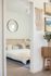 view of inside of bedroom with white bed from hall
