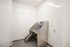 High-End Apartments in Pearl District, OR - ORO - A Pet Washing Station with a Built-in Tub, Small Access Stairs, and a Handheld Sprayer Hose in a Utility Room.