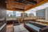 Downtown Portland OR Apartments Near Portland State University - ORO - Rooftop Lounge With Fireplace, Plush Seating, Chairs, Tables, String Lights, And Panoramic City Views.