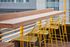 bar with yellow bar chairs at oro apartments rooftop