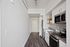 Studio Apartments in Downtown Portland OR - ORO - An interior shot of the kitchen featuring Stainless Steel Appliances, Grey Countertops, White Cabinetry, Wood-Style Flooring, and Tile Backsplash