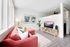 living room with red sofa, vinyl wood like flooring and tv console at novus woodstock apartments