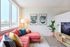 Portland Apartments- Novus- Living Room with Spacious Windows, Wood-Style Flooring, and Pink Couch