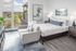 Pet-Friendly Apartments In Williams District, OR - Spacious Bedroom With Floor-To-Ceiling Windows And Vinyl Wood Flooring.
