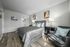 bedroom with faux hardwood flooring and two black bedside drawers and bed with grey cover at peoria grand apartments