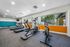 fitness center with treadmills facing the window looking at the pool at peoria grand apartments