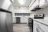 Updated kitchen with stainless steel dishwasher and stove/over with white cabinets and faux wood plank flooring