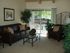 carpeted living room with leather sofas and a metal and glass coffee table at plumas garden apartments
