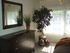 bedroom with dresser and mirror on the wall and decorative plant in the corner near window at plumas garden apartments