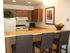 kitchen with bar area and three bar height chairs at plumas garden apartments