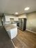 kitchen with black appliances bar area and wood inspired flooring at the creek at south carson