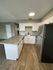 kitchen with black appliances bar area and wood inspired flooring at the creek at south carson