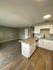 kitchen with black appliances bar area and wood inspired flooring and living room at the creek at south carson
