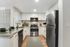 1-Bedroom Apartments in Reno, NV - Redfield Ridge - Kitchen with Stainless Steel Appliances, White Cabinets, Granite Countertops, Wood-Style Flooring, and a Window
