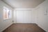 Bedroom with large windows and brown carpet and large closet with sliding doors