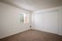 bedroom with brown carpet and large closet with sliding doors