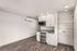 kitchen and living area with wood-style flooring, built-in shelving, and large windows