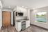 kitchen and living area with wood-style flooring, built-in shelving, and large windows
