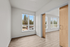 spacious bedroom with sliding barn doors and wood-style plank flooring