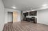 Studio kitchen with stainless-steel dishwasher, oven, range, microwave, and refrigerator, granite countertops and white subway-style backsplash featuring a barn-door style closet