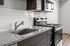 Modern kitchen with Stainless steel appliances, granite countertops, and durable wood-style plank flooring