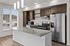 Studios in Bend, OR - The Hixon - Kitchen with Wood-Style Flooring, a Kitchen Island with a Granite Countertop, Stainless Steel Appliances, Cabinetry, Pendant Lights, and a Large Window.