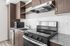 Large kitchen with stainless steel appliances, granite countertops and backsplash