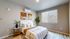 Second bedroom with vinyl plank flooring and large windows