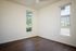 Bedroom with wood flooring and two windows