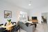 open floor plan with grey sofa and circular dining table behind