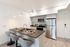 Milwaukie, OR Pet-Friendly Apartments - Henley Place - Kitchen With Quartz Countertops, Whirlpool Stainless Steel Appliances, Luxury Vinyl Flooring, Kitchen Tile Backsplash, And Breakfast Bar