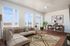 Spacious living room with large windows and abundant natural light, a dining space, and luxury vinyl plank flooring