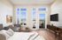 Studio apartment with virtually staged lounge area, queen sized bed and rolling bar seating area. Large windows allowing natural light with a patio and amazing view complete with patio furniture