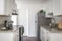 virtually staged kitchen with faux hardwood flooring and white cabinets and stainless steel appliances and decorative accessories