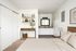 virtually staged bedroom with brown carpet sliding closet doors and bed with beige comforter and a dresser at its corner