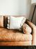 leather sofa with a white accent pillow in the corner