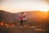 two women looking at the sunset at the top of a hill