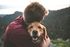 man embracing golden retriever