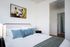 1 Bedroom Apartments In Central Portland OR - Jute - Bedroom With A Queen Bed, Stylish Wall Art, And An En-suite Bathroom Featuring In-unit Washer And Dryer.