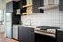 Central Portland OR Studios For Rent - Jute - Kitchen With Stainless Steel Appliances, Gas Range, Microwave, Dishwasher, Dark Cabinetry, White Tile Backsplash, and Sleek Countertops