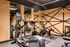 Pet-Friendly Luxury Apartments In Portland Or - Jute - Fitness Center With Cardio Equipment, Mirrored Walls, Wood Paneling, and Contemporary Lighting.