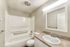 full shower-tub combo and faux wood flooring at quad apartments