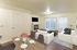 living room with white couches and black coffee table and faux wood like flooring at fairview court