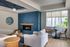 Albany, OR, Apartments with In-Unit Washer and Dryer - Creekside Meadows - Community Space Anchored by Wood Floors, a Sofa, Armchair, Coffee Tables, Windows with Blinds, and a Fireplace.