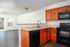 kitchen with wood cabinets and all black appliances and living area