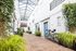 paved walkway with decorative plants near the doors