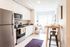 kitchen with stainless steel appliances and living room in the background