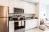 kitchen with stainless steel appliances and living room in the background