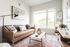 living room with leather sofa and large area rug with a coffee table