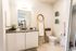 bathroom with quartz vanity and white cabinets